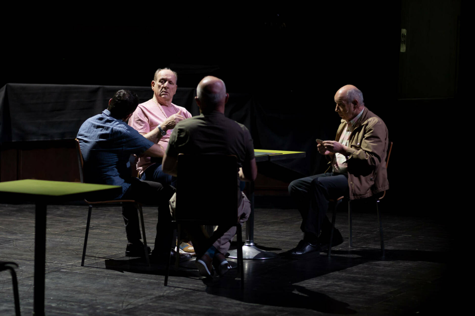 Des comédiens assis autour d'une table dans le spectacle Marius de Joël Pommerat