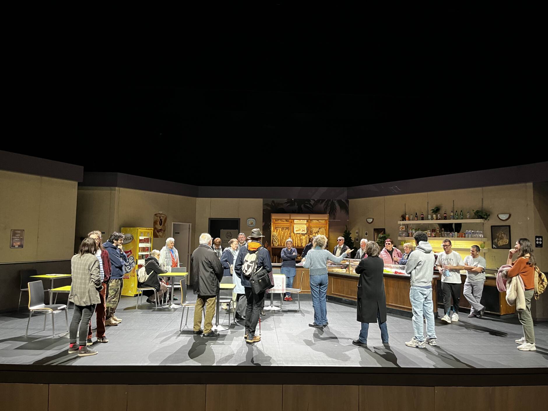  Un groupe de personnes visitent le décor de la pièce de théâtre Marius. 